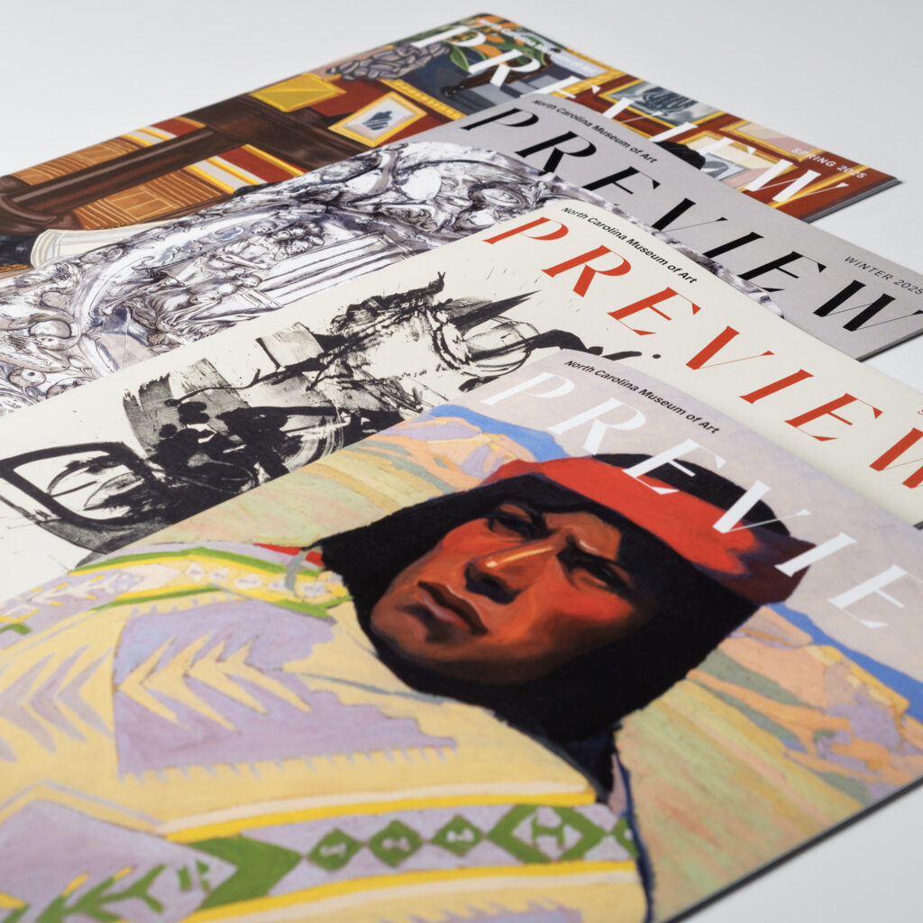 Four magazines fanned out on a white table.