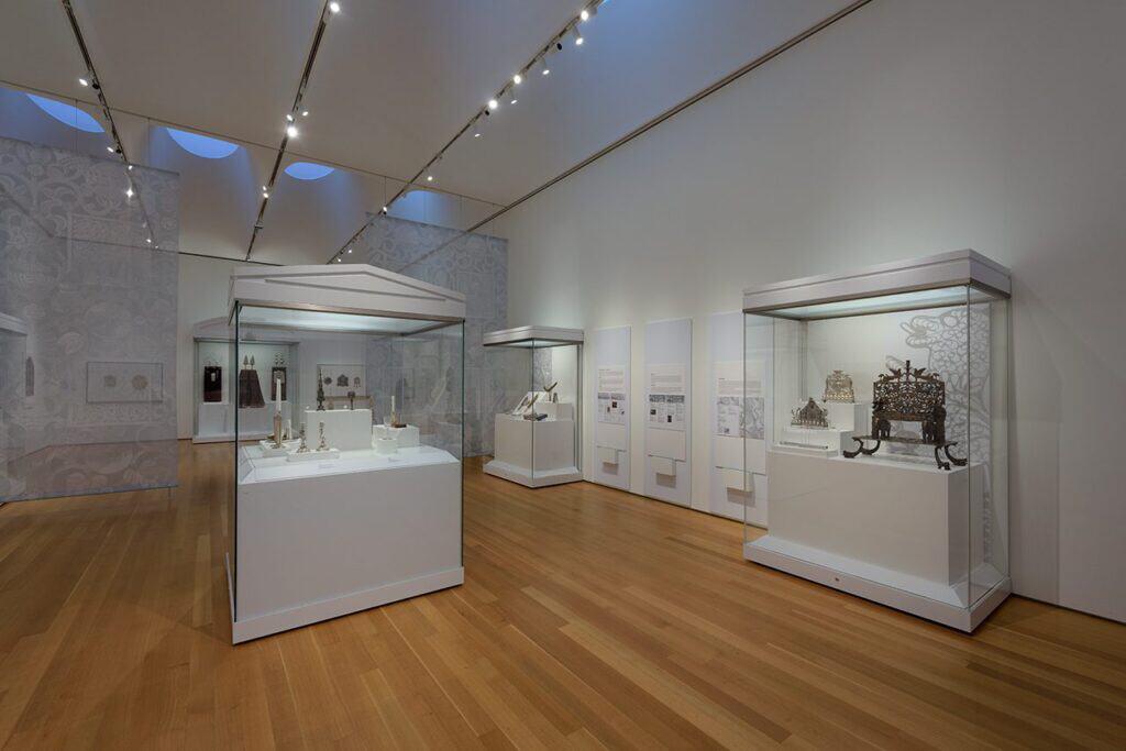 An art gallery filled with large display cases exhibiting Judaica.