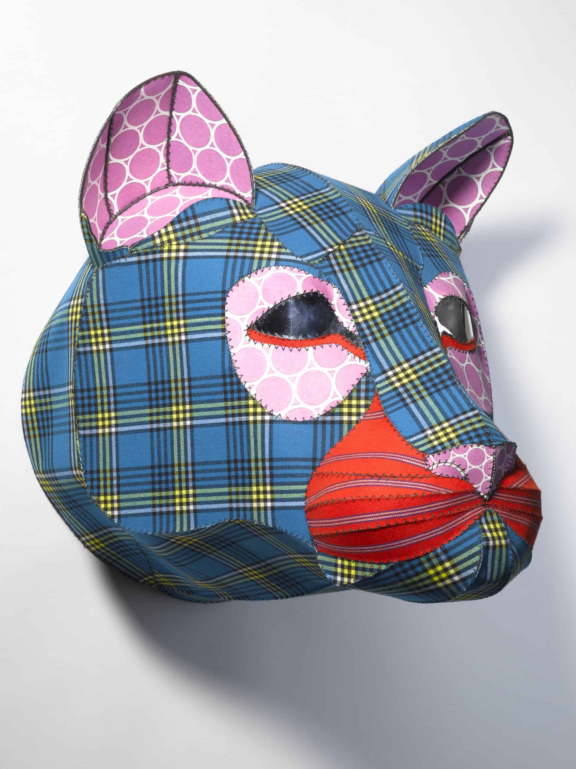 A sculpture of a disembodied lion's head constructed of multiple colorful patterns. 