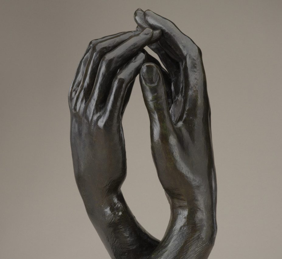 A sculpture of two right hands facing each other with fingertips touching.