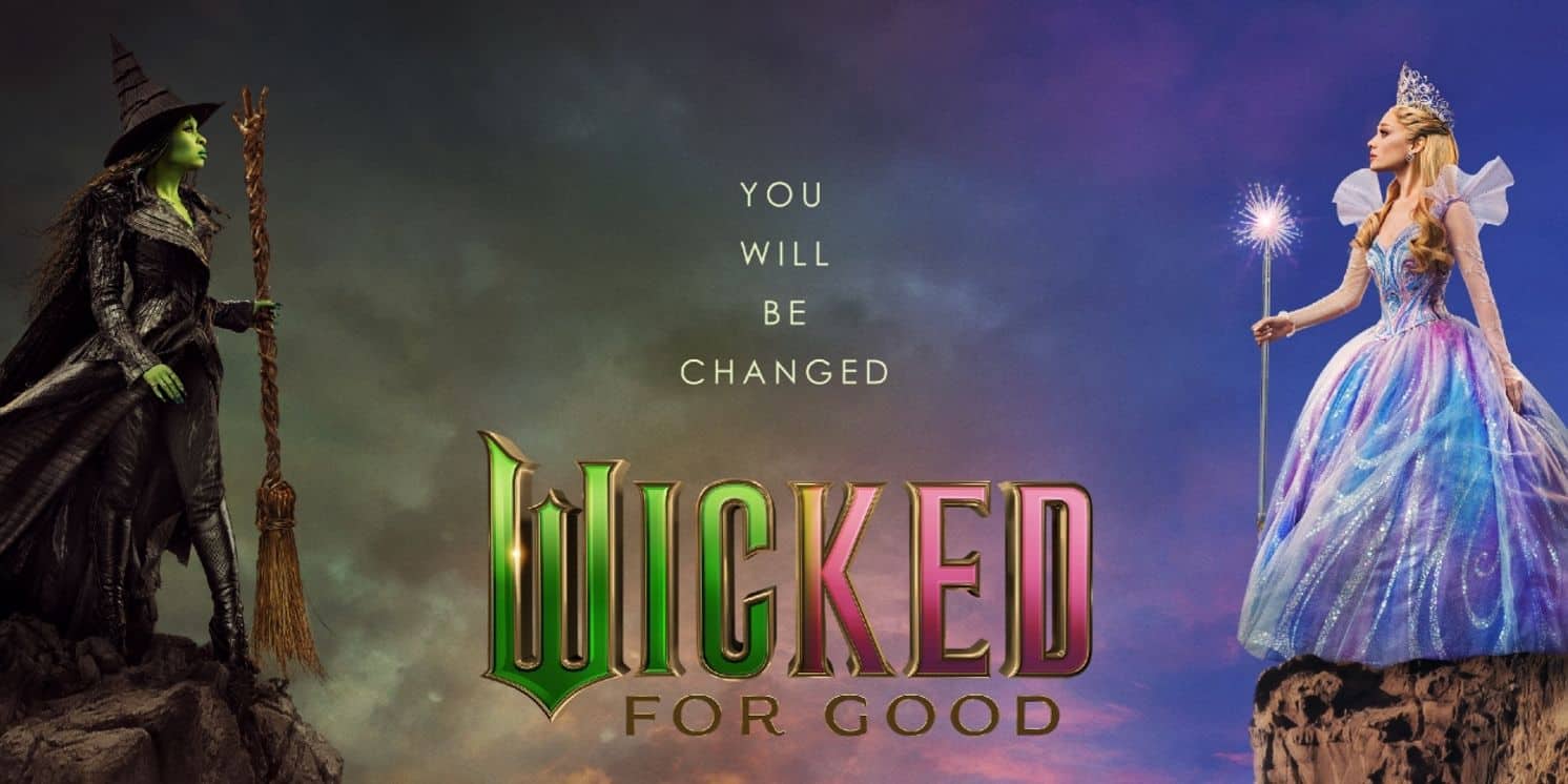 Movie poster of a woman with green skin and a broom on a cliff facing a woman with a crown and wand on an opposite cliff.