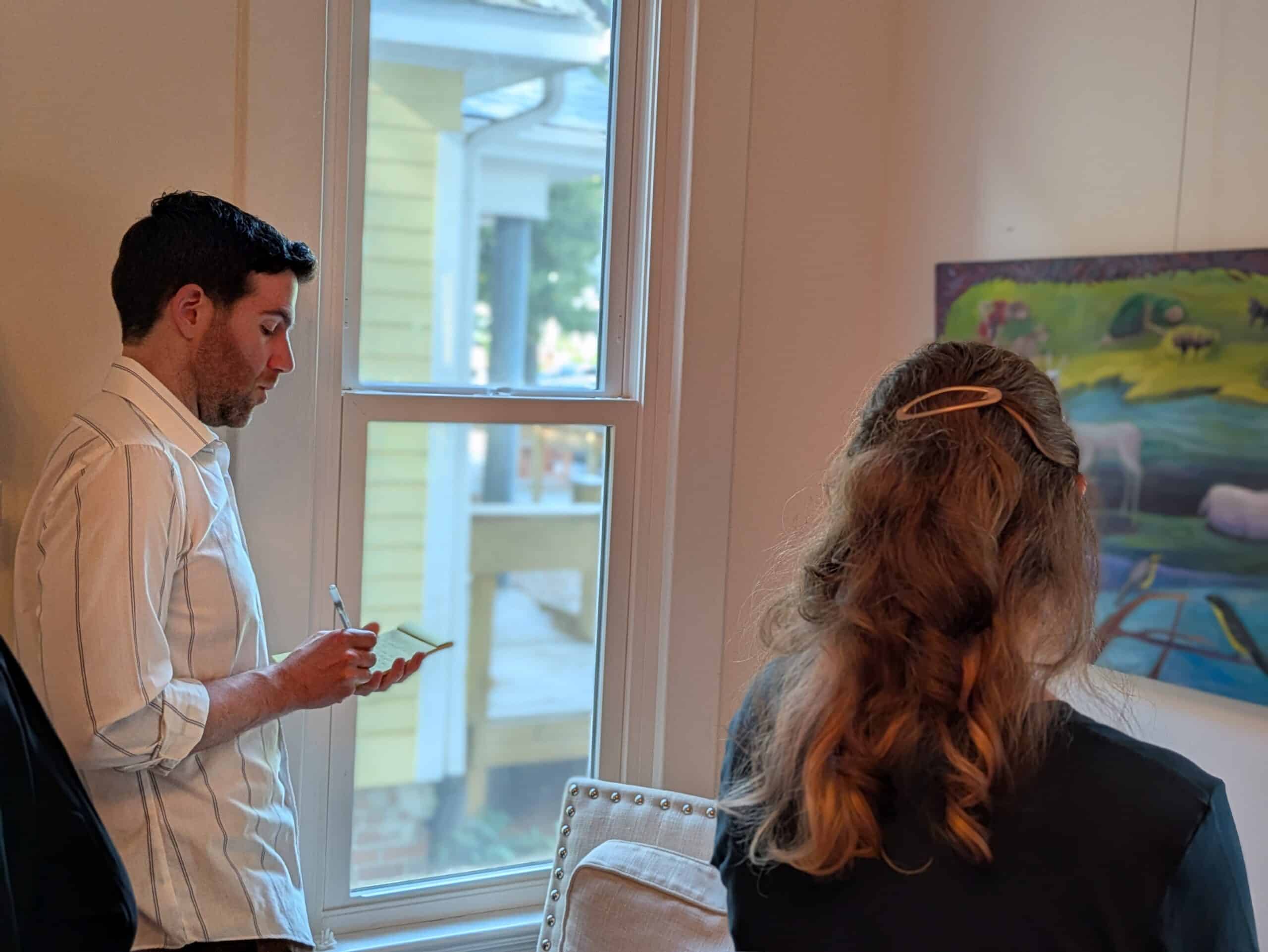 Courtesy of Redbud Writing Project Alt text: Two people take notes in journals while looking at a work of art.