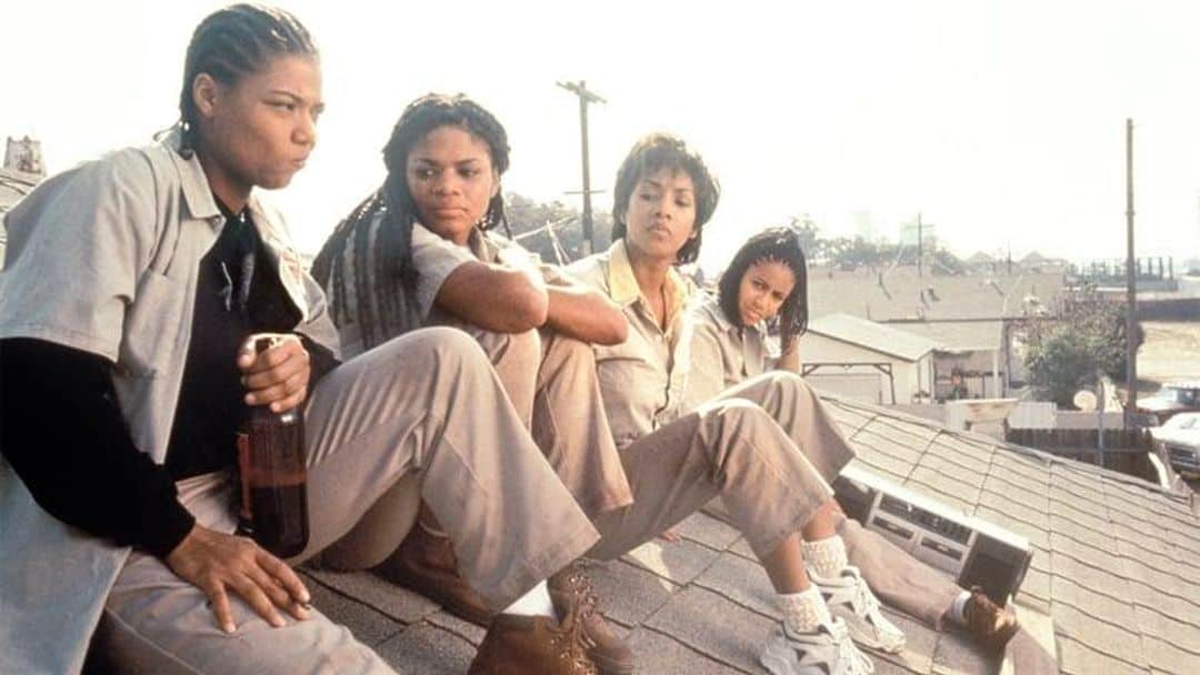 Four women sit on a rooftop.